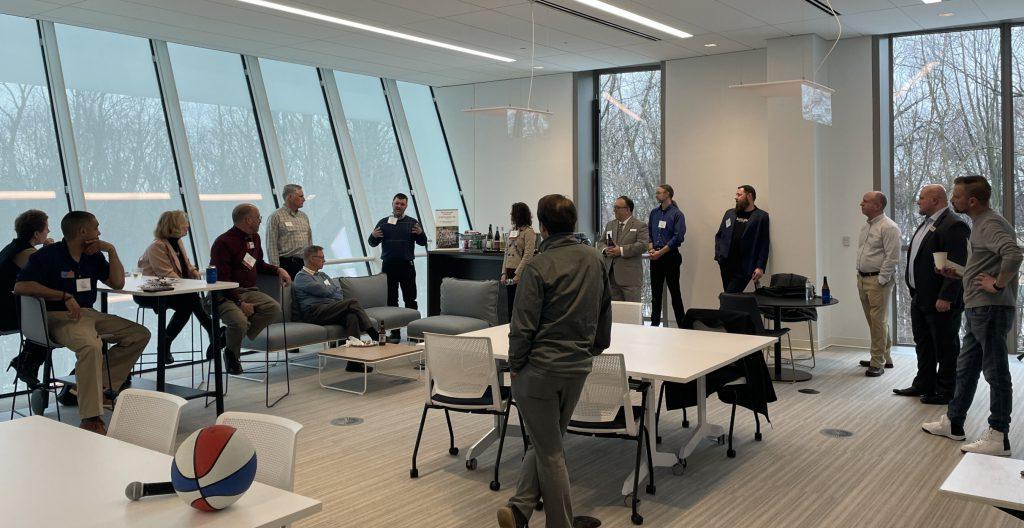 A group of people stand in a circle introducing themselves to one another.